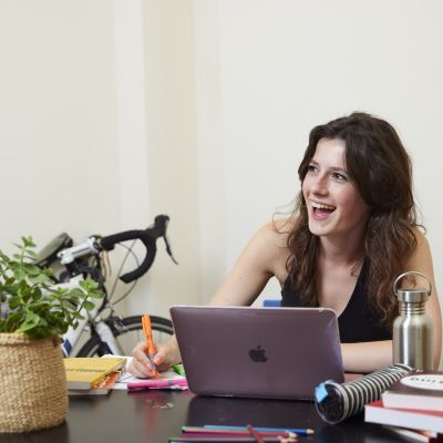 A girl sits at a desk and smiles